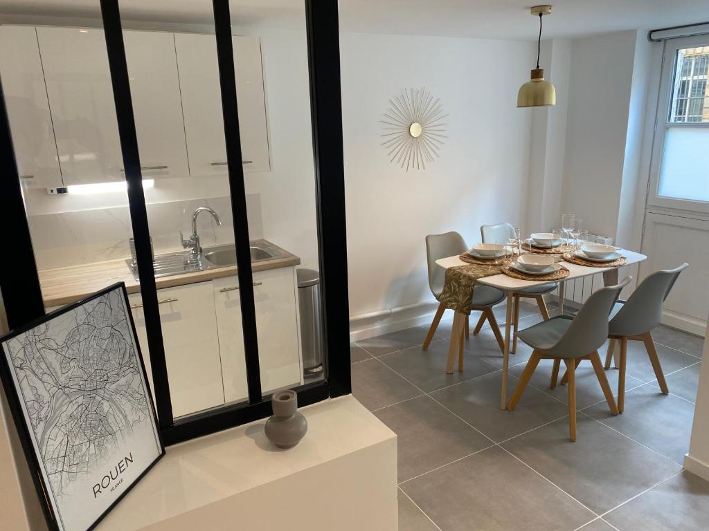 eine Küche und ein Esszimmer mit einem Tisch und Stühlen in der Unterkunft Le Palm ✧ Duplex centre historique Rouen in Rouen