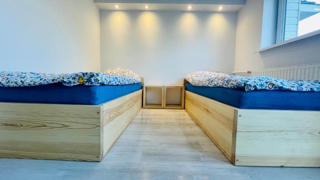 two beds in a room with blue covers at Długa 100 in Charzykowy