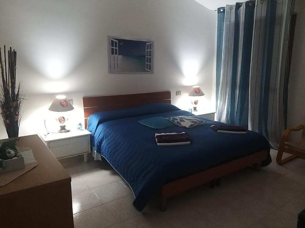 um quarto com uma cama com um edredão azul em By Azzurra Tra Mare e Montagna em Sìnnai