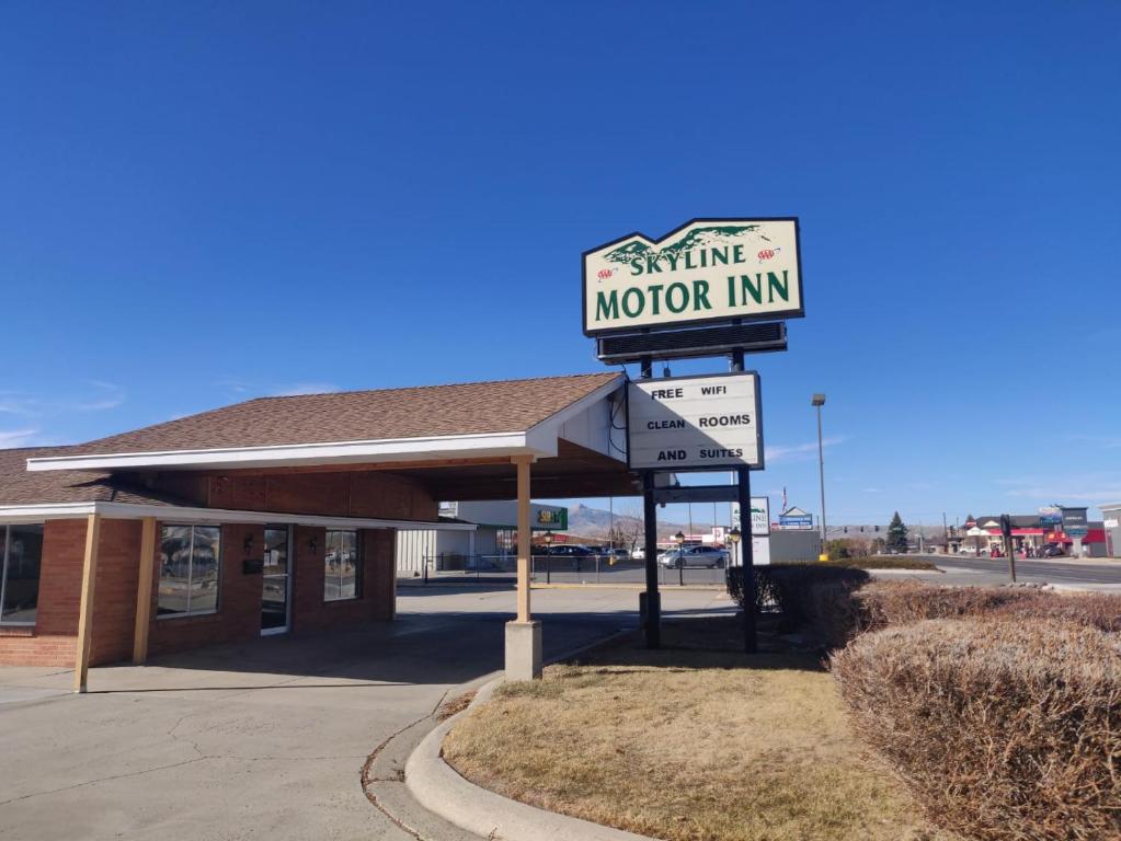 una señal para una posada de motores frente a un edificio en Skyline Motor Inn en Cody