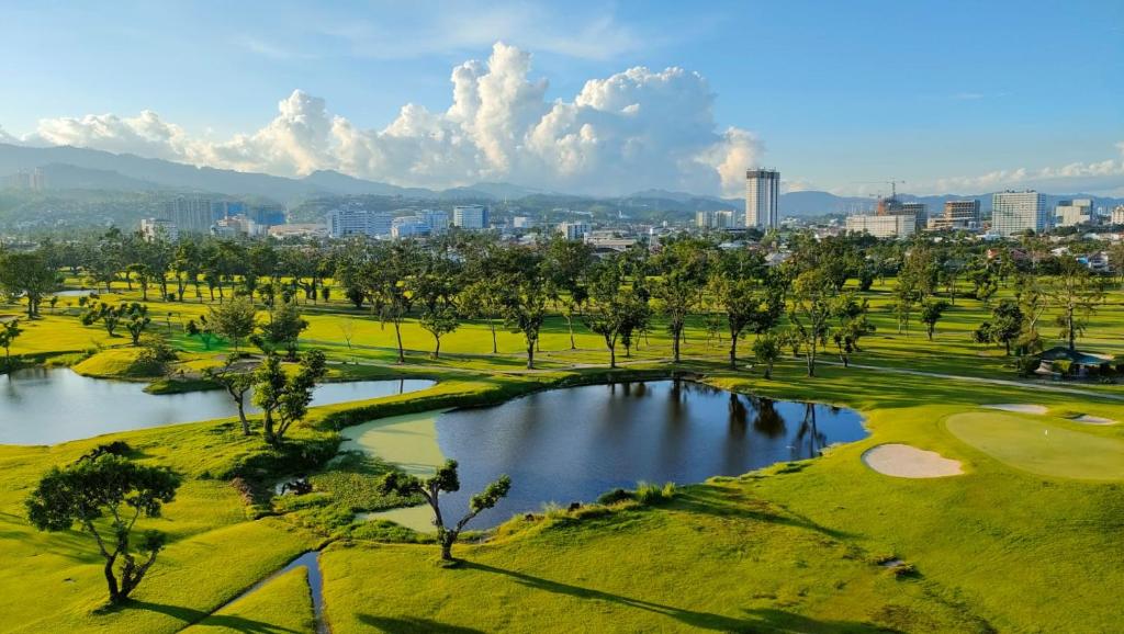 an aerial view of a golf course with a pond at Dreamy 2BR condo, with a golf course view in Cebu City