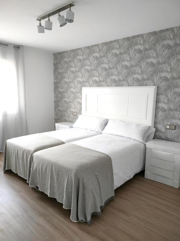 A bed or beds in a room at Second Home Arzúa apartamentos