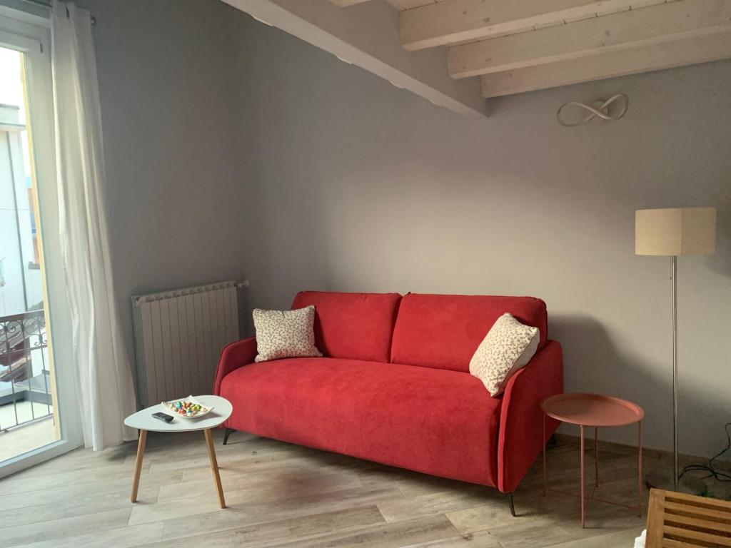 a red couch in a living room with a table at Le Ochette Di Stresa in Stresa