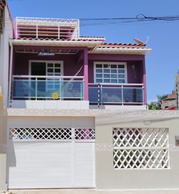 a house with a white gate and a pink at Aconchego in Maragogi