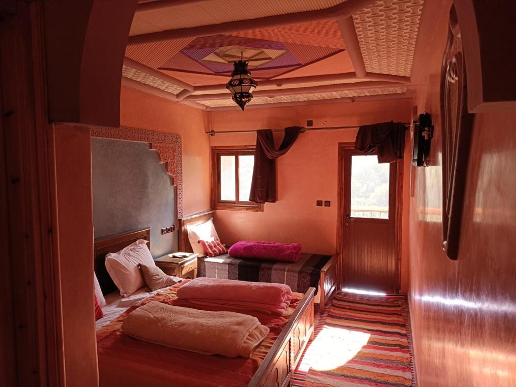 ein Zimmer mit 2 Betten und einem Sofa darin in der Unterkunft Riad Atlas Sultana in Imlil
