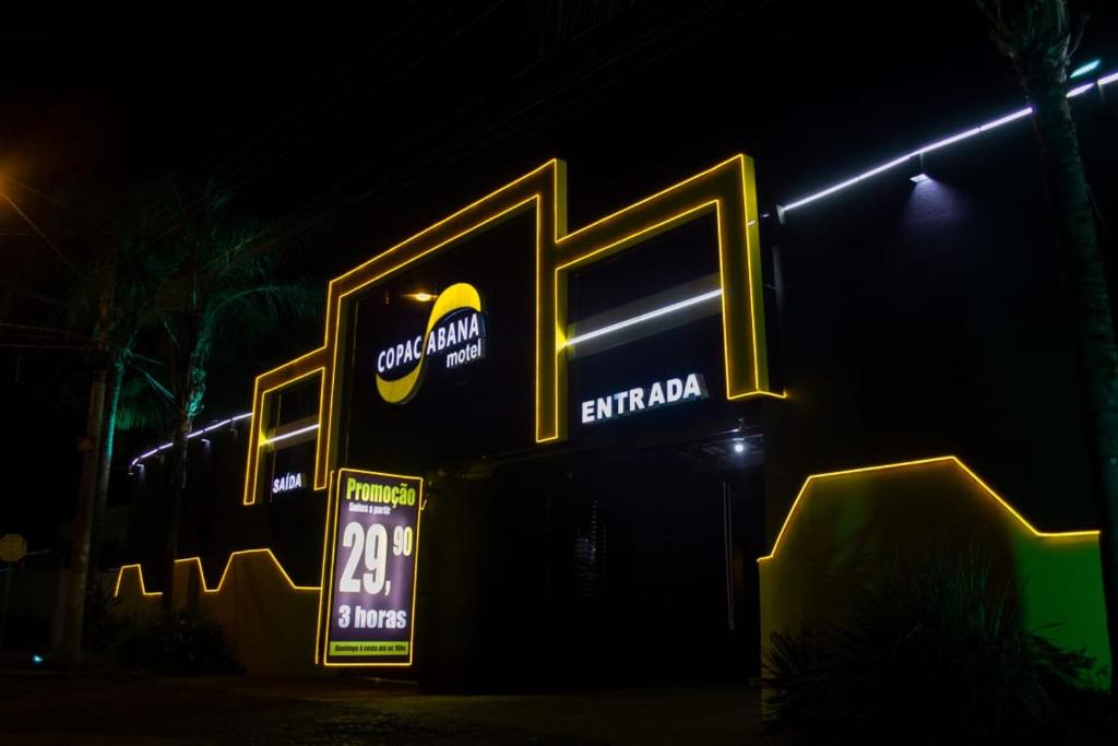 a sign for a cola soda shop at night at Motel Copacabana in Ribeirão Preto