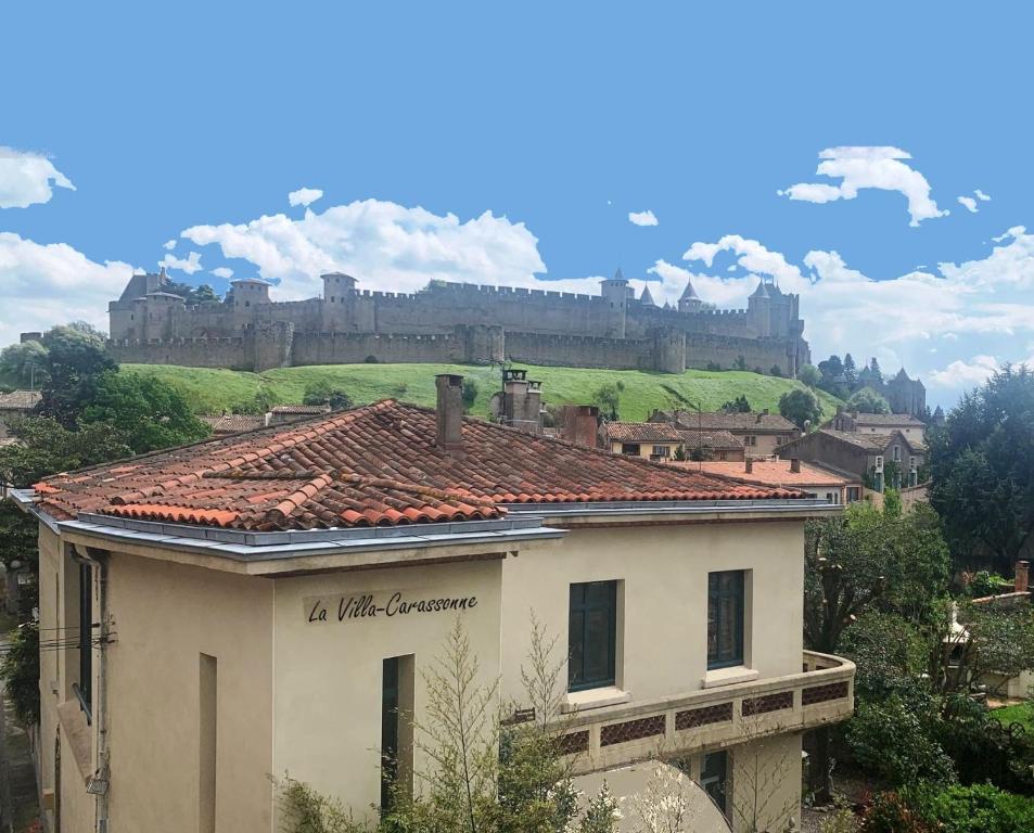 un bâtiment avec un château en arrière-plan dans l'établissement La Villa Carcassonne, Cité 8 min à pieds, Clim, Piscine, Full Wifi, Borne 7,5kW, Vélo élect, Parking privé, à Carcassonne