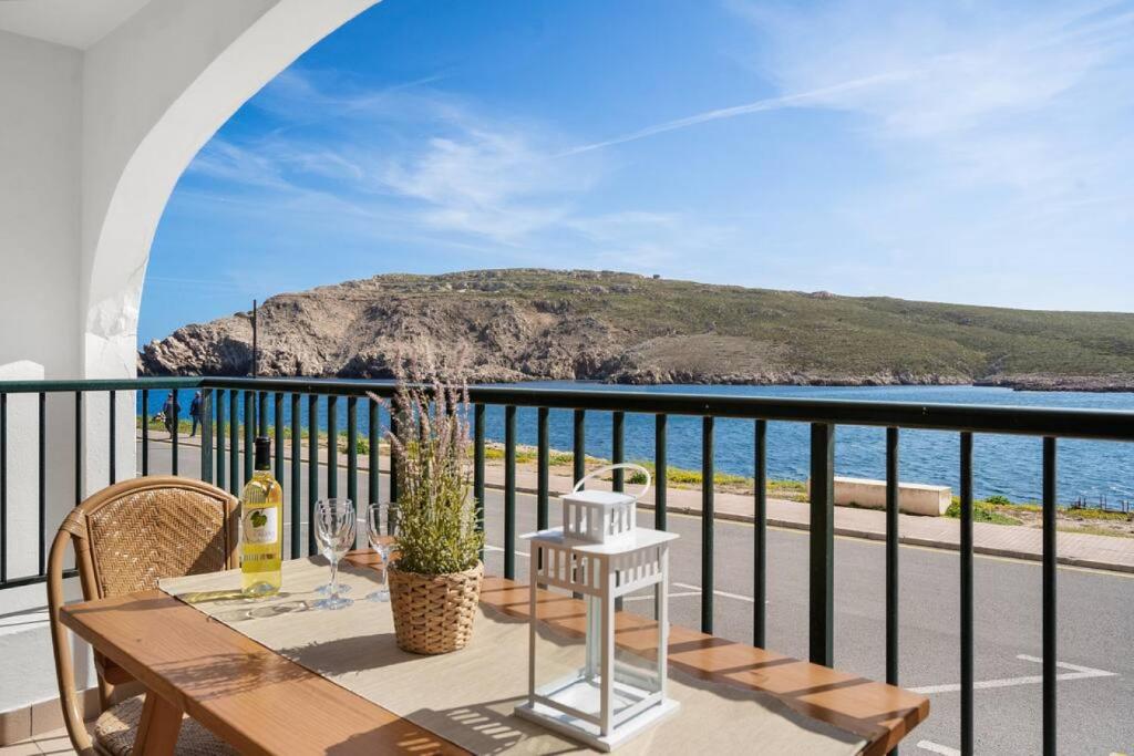 uma mesa numa varanda com vista para o oceano em Apartamento Tramontana 113BJ em Fornells