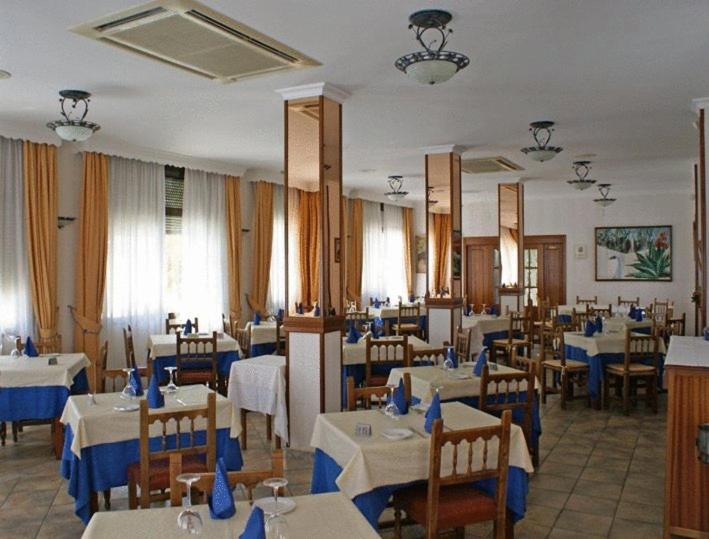 a dining room with tables and chairs with blue napkins at PARAISO PLAYA Hotel in Isla Cristina