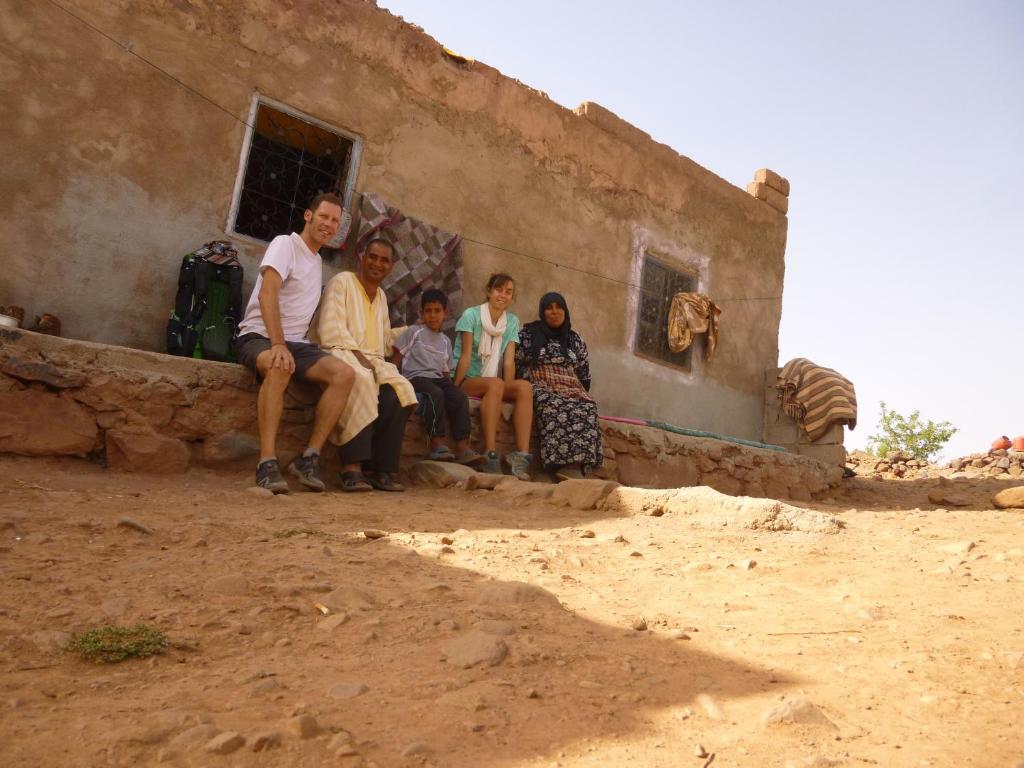 un grupo de personas sentadas afuera de un edificio en LODGE bennouri, en Telouet