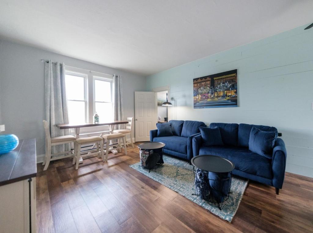 een woonkamer met een blauwe bank en een tafel bij Robin's Nest - Miami U, Weddings or Spooky Nook! in Hamilton