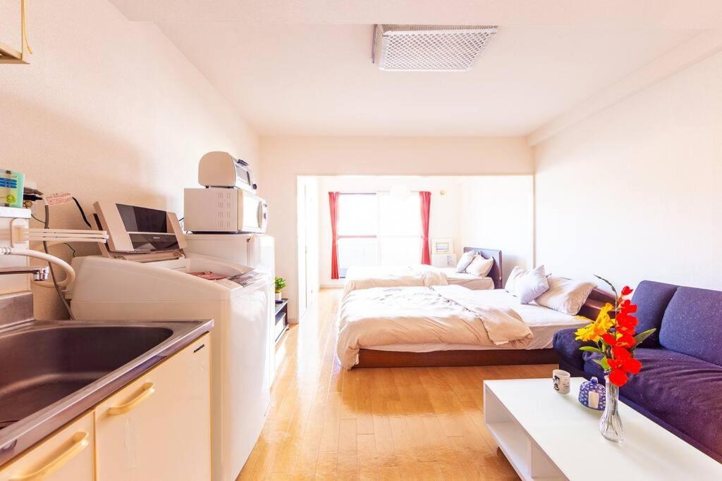 een kamer met een bed en een keuken met een wastafel bij COMMENCE Ⅲ in Sapporo
