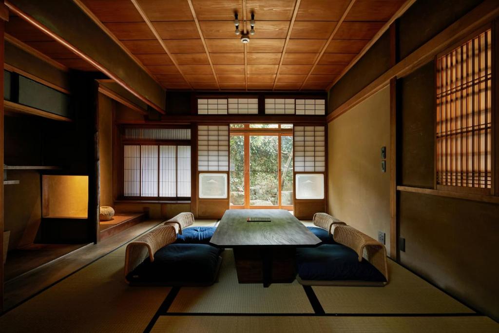 una sala da pranzo con tavolo, sedie e finestra di Umeyu no yado by YADORU KYOTO HANARE a Kyoto