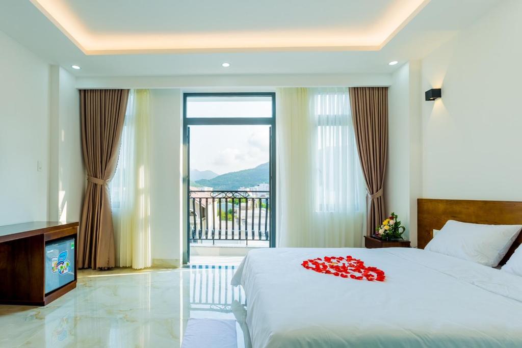 a bedroom with a bed and a large window at Hồng Gấm Hotel in Quy Nhon