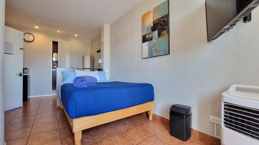 um quarto com uma cama azul num quarto em Hostal GGG em Ensenada