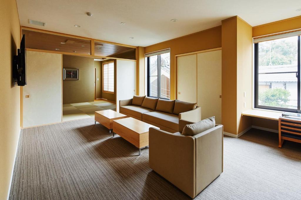 ein Wohnzimmer mit einem Sofa und einem Tisch in der Unterkunft Onsen no yado Gion Maisen Bettei by YADORU KYOTO HANARE in Kyoto
