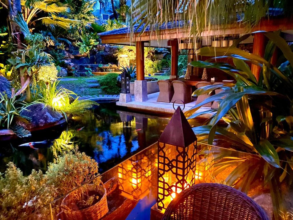 Villa on The Rocks, 4 bedrooms, Phuket في شاطئ سورين: بيت فيه بركه وسط حديقه
