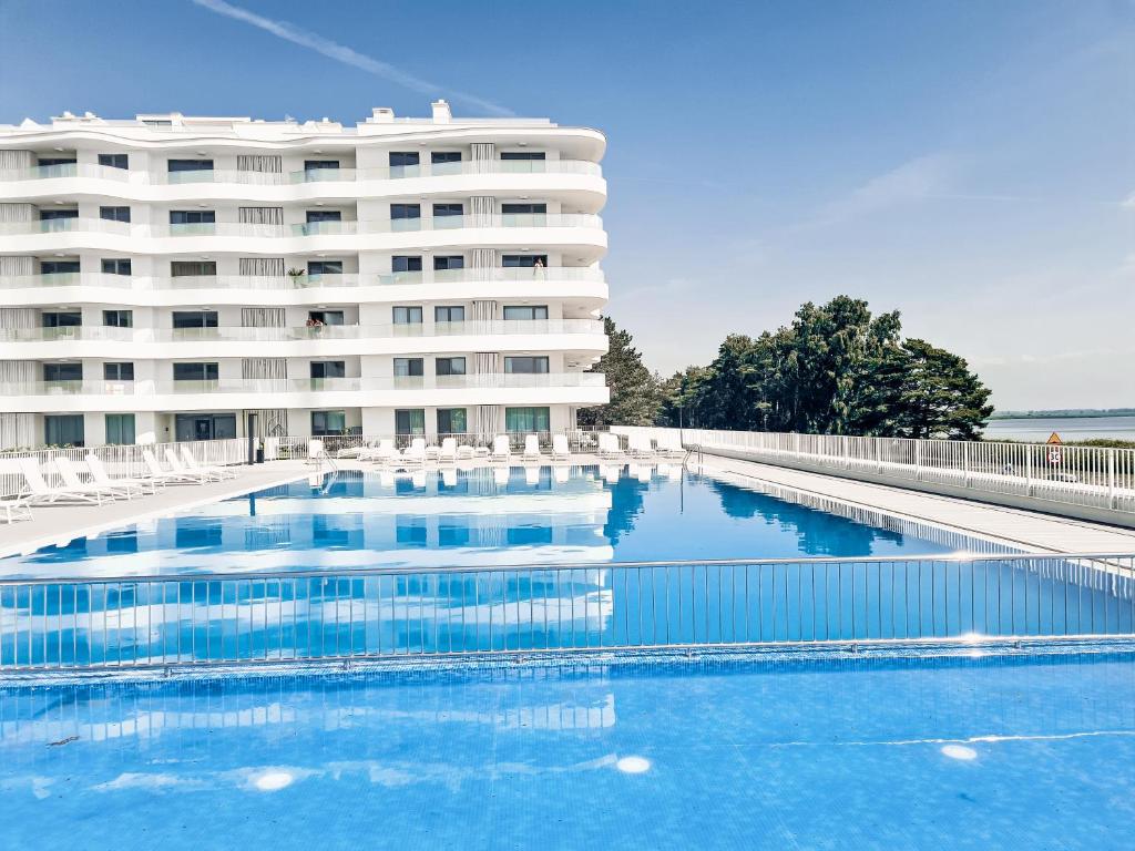a hotel with a swimming pool in front of a building at Apartment 1007 Rogowo Pearl in Mrzeżyno