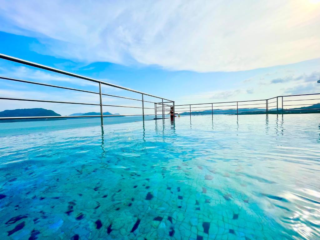 a pool of water with a view of the ocean at The Cube Langkawi in Kuah