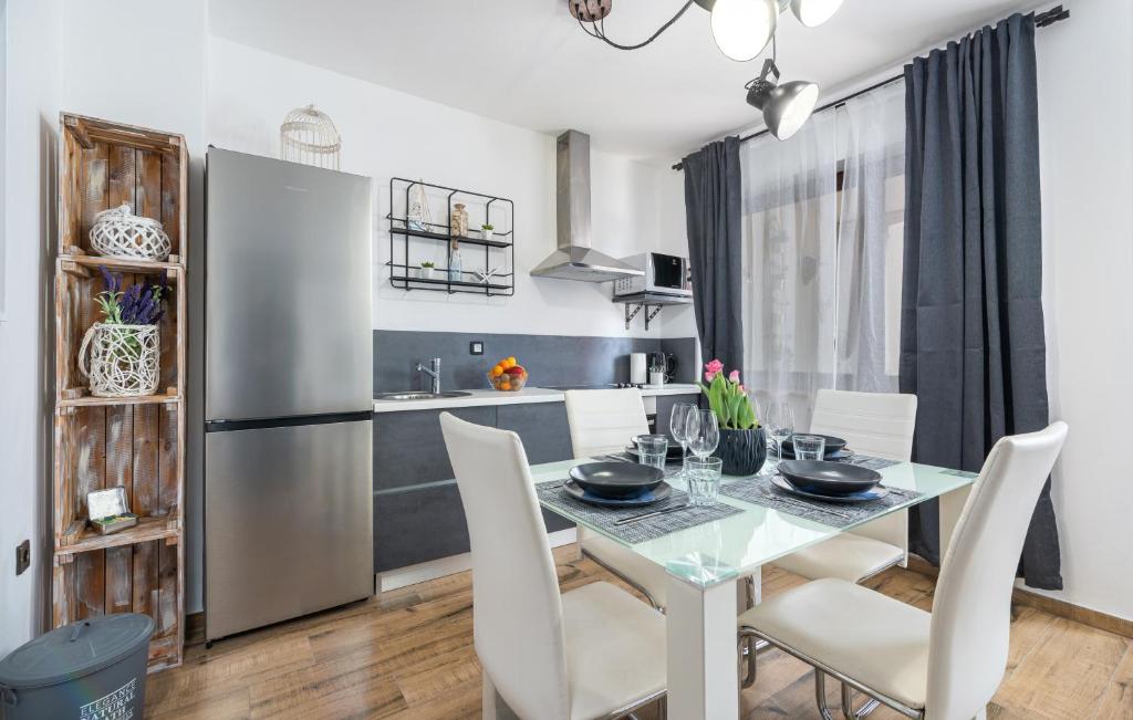 a kitchen and dining room with a table and a refrigerator at Apartments Ariana in Umag