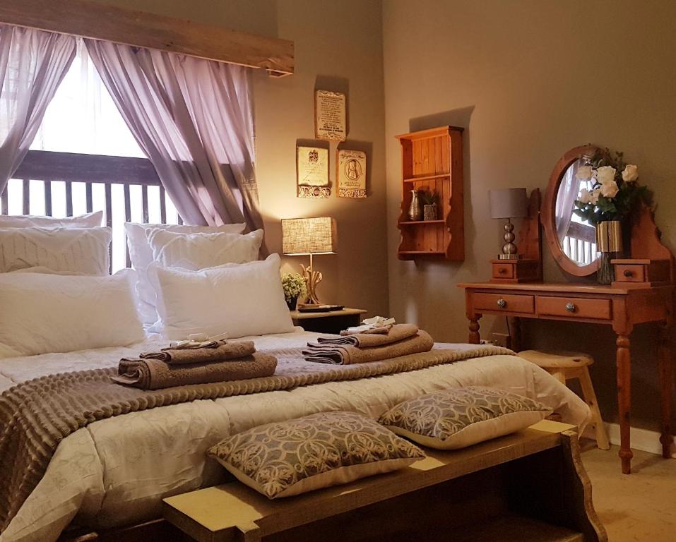 a bedroom with a large bed with towels on it at Rubyred Cottage in Bloemfontein