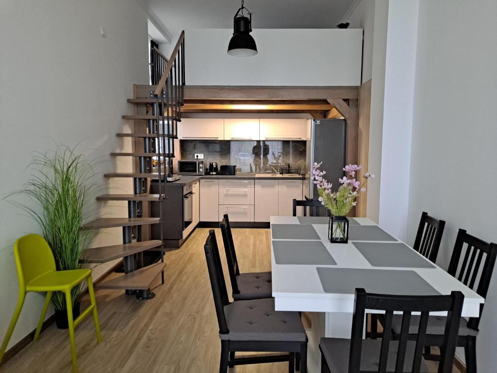 ein Esszimmer und eine Küche mit einem Tisch und Stühlen in der Unterkunft Vízparti Silver X apartman in Siófok