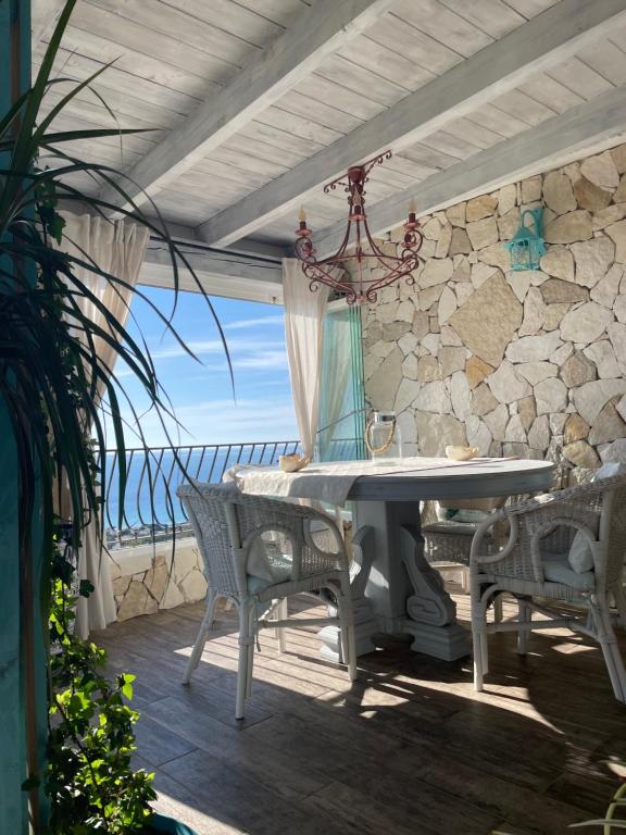 un tavolo e sedie su un patio con vista sull'oceano di Villa turchese a Costa Rei