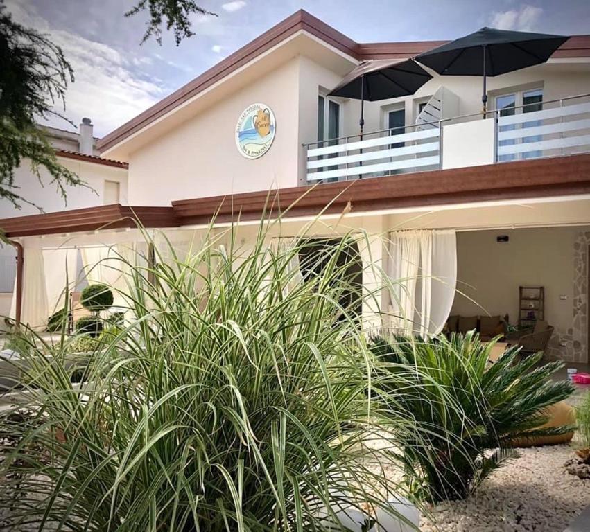 a house with an umbrella on top of it at Appartamento in Villa in Ginosa Marina