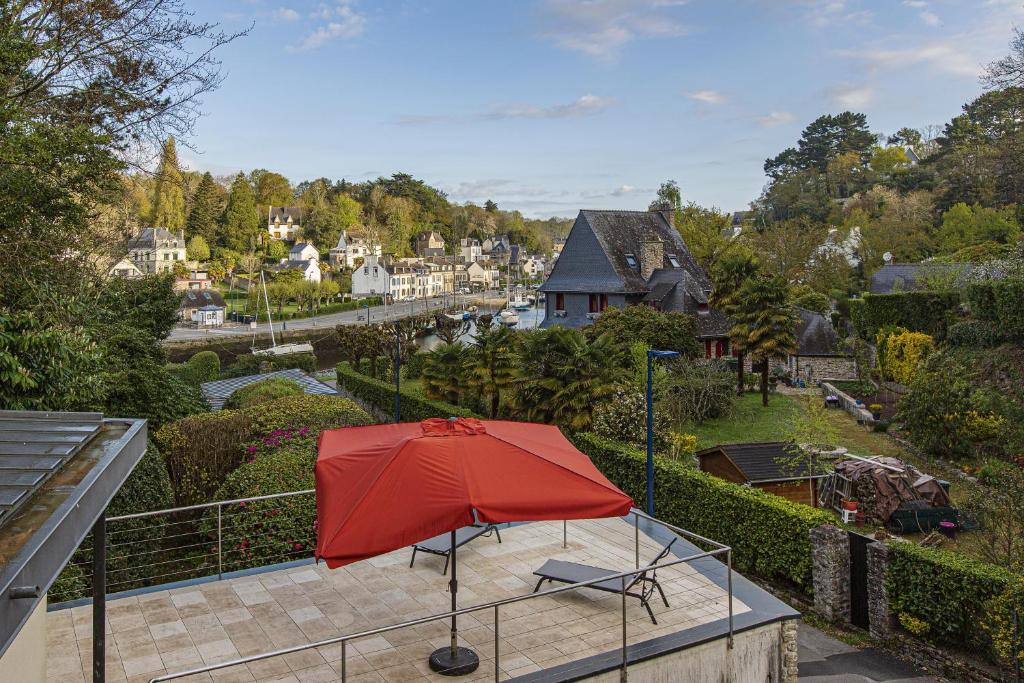 - un parasol rouge assis au-dessus d'une terrasse dans l'établissement Villa Ty Sant Buzit, à Pont-Aven