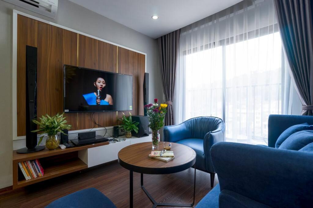 salon z telewizorem i niebieską kanapą w obiekcie *Ha Long Homestay @ Sunrise Apartment- 4 BR w Ha Long