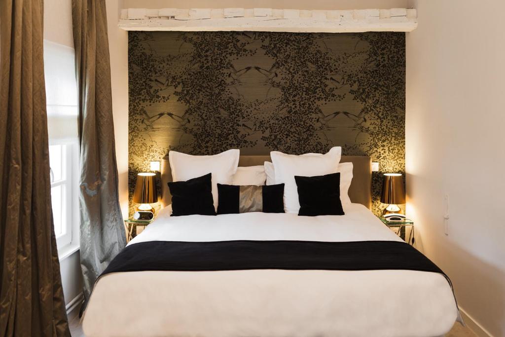 a bedroom with a large bed with black and white pillows at Clarance Hotel Lille in Lille