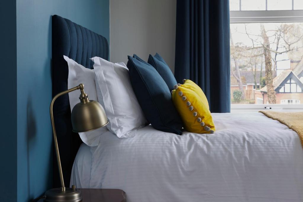 Un dormitorio con una cama con paredes azules y una ventana en Sentry Mead Hotel en Totland
