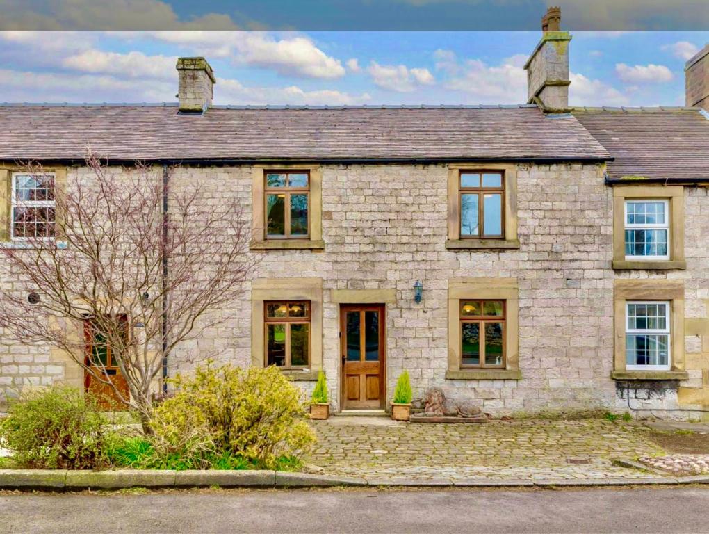 uma antiga casa de pedra com uma fachada de tijolo em Red Lion House em Hartington