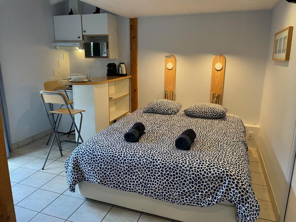 a bedroom with a bed with a black and white blanket at Le Petit Havre in Lacanau-Océan