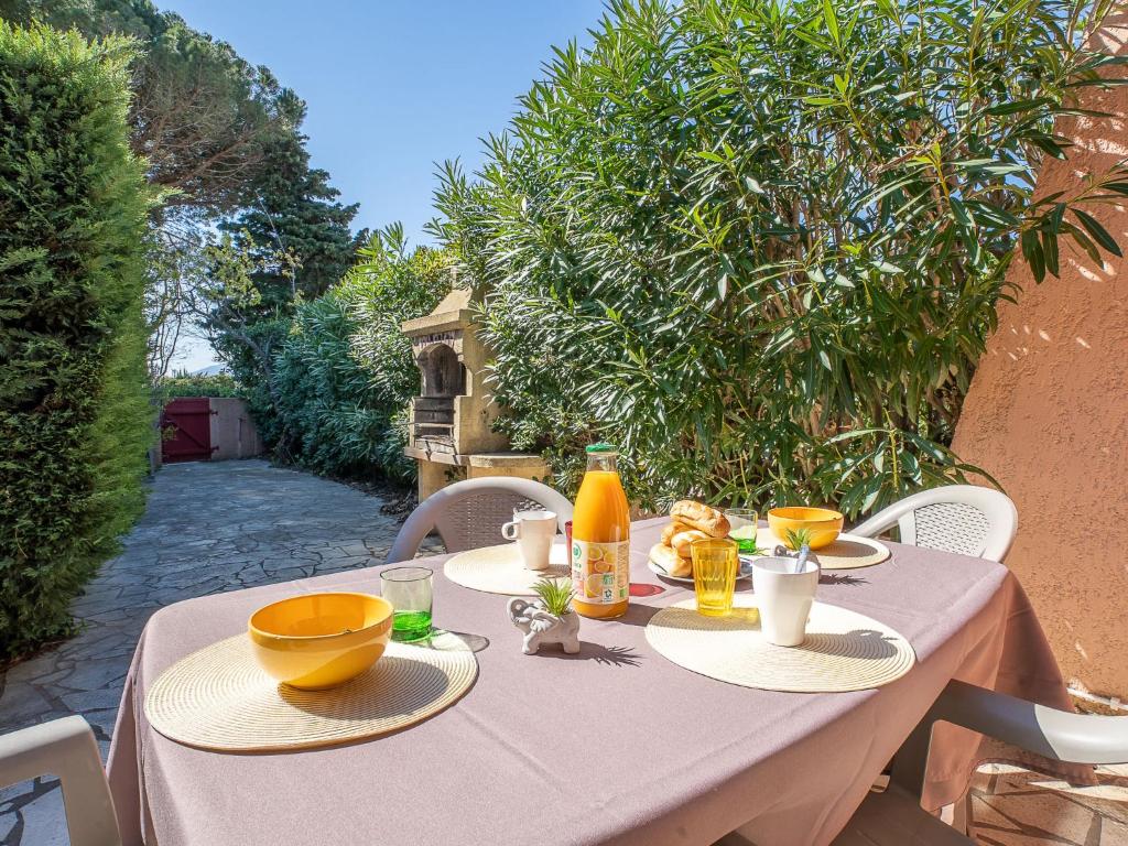 a table with yellow bowls and plates of food on it at Holiday Home Thalassa-3 by Interhome in Saint-Cyprien-Plage