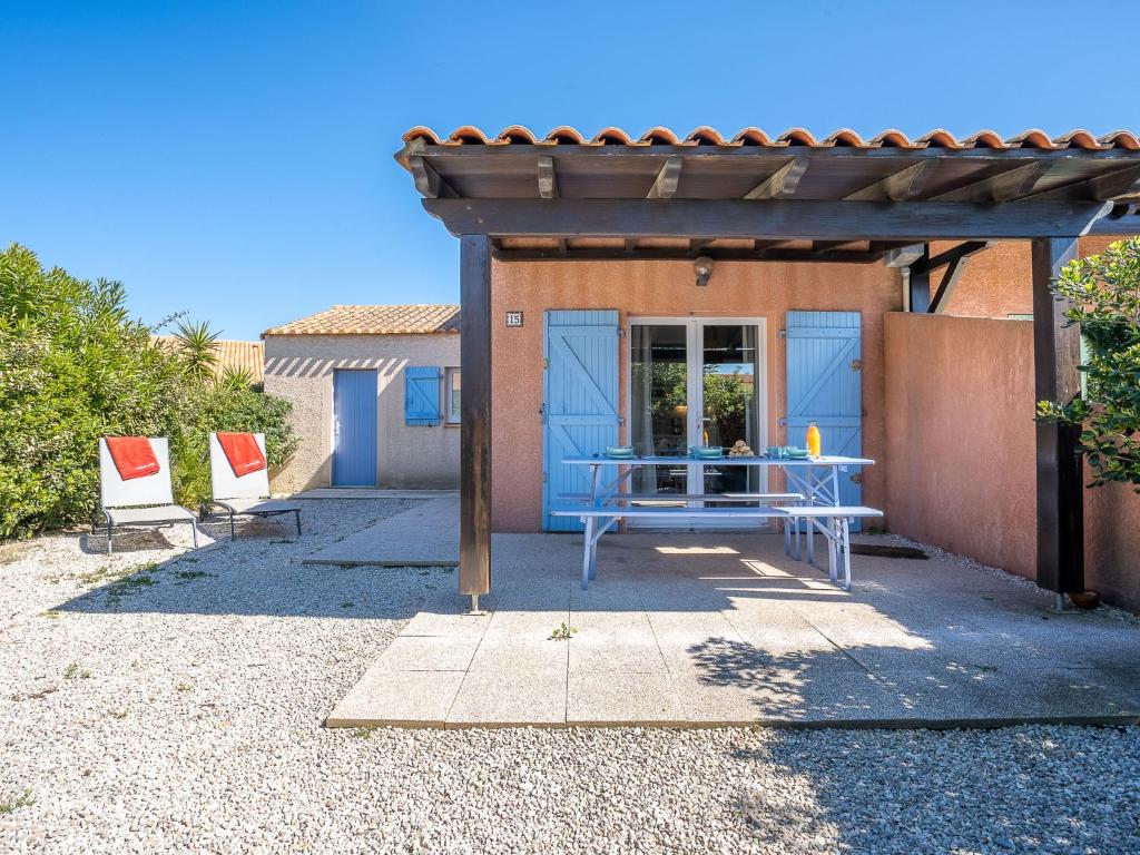 a patio with a blue table and two chairs at Holiday Home Les Marines du Roussillon by Interhome in Saint-Cyprien-Plage