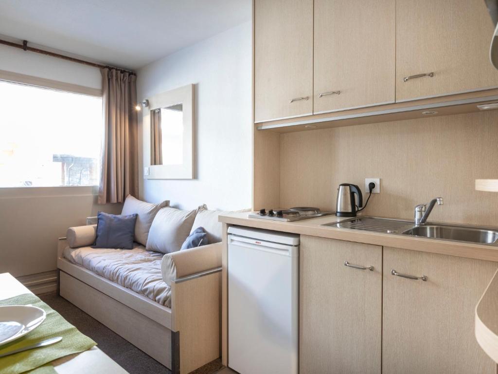 a kitchen and living room with a couch at Apartment Vanoise 167 by Interhome in Val Thorens