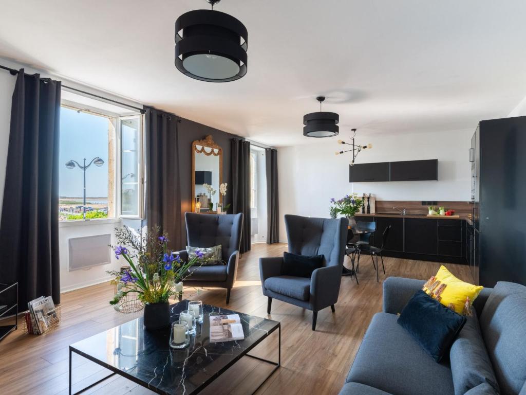 uma sala de estar com um sofá e uma mesa em Apartment Ô de Mer - ETL300 by Interhome em Étel