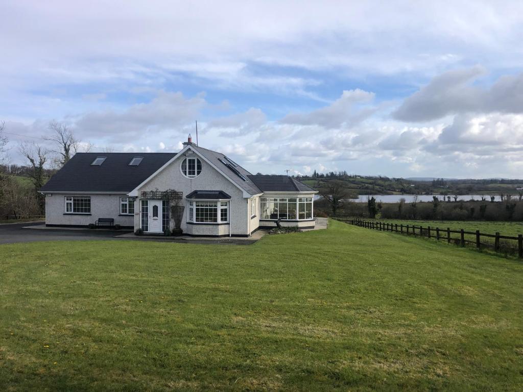 Casa blanca con un gran patio verde en Lough Aduff Lodge 5 minutes from Carrick on Shannon, en Leitrim