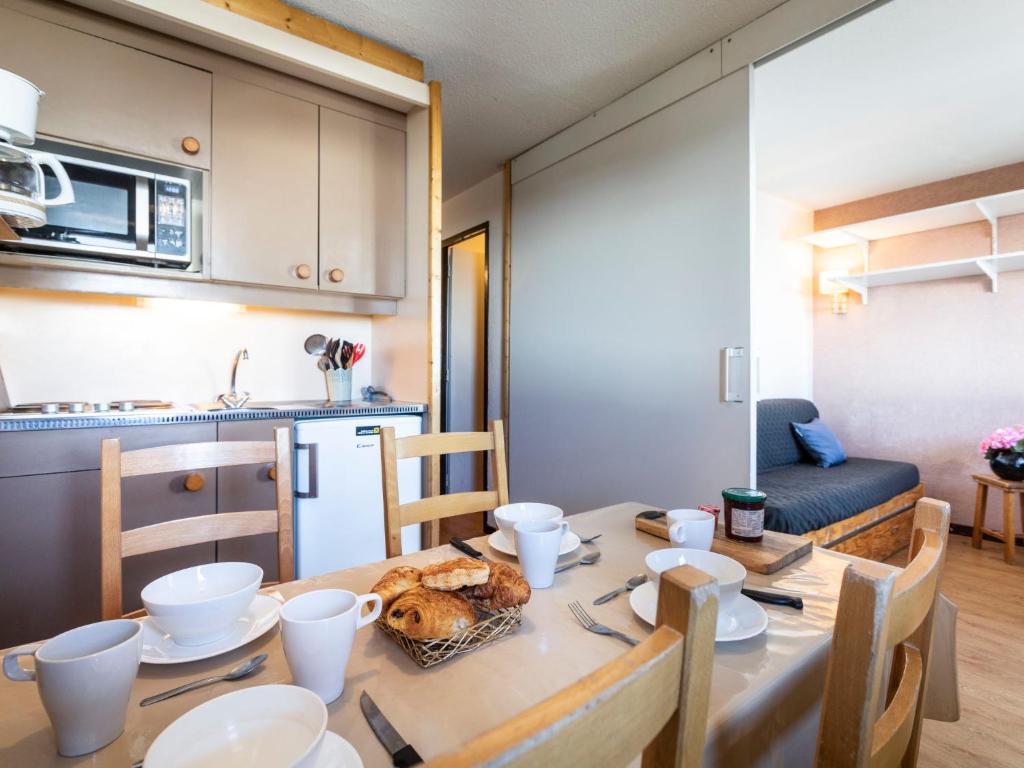 une cuisine et une salle à manger avec une table et de la nourriture. dans l'établissement Apartment Arcelle 308 by Interhome, à Val Thorens