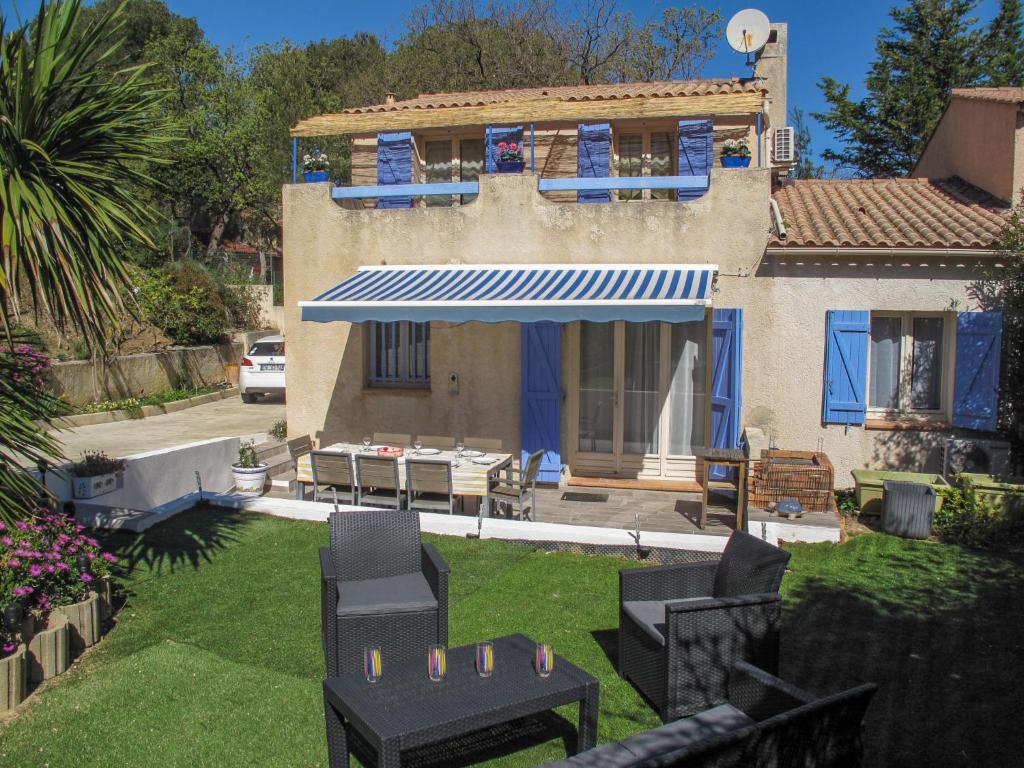 シス・フール・レ・プラージュにあるHoliday Home De Manou - SFP135 by Interhomeの椅子のある庭と青い屋根の家