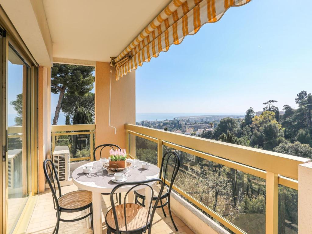 balcón con mesa, sillas y vistas en Apartment Domaine du Clairfontaine by Interhome, en Niza
