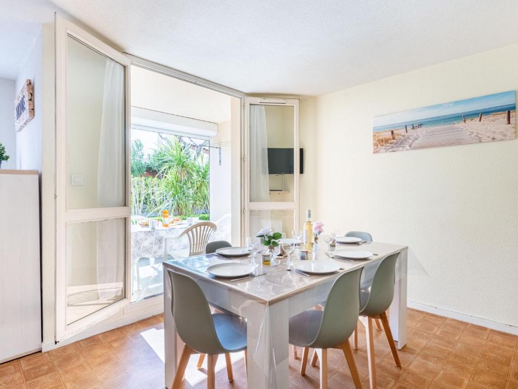 une salle à manger blanche avec une table et des chaises dans l'établissement Apartment Les Sables d'Or-8 by Interhome, au Grau-du-Roi
