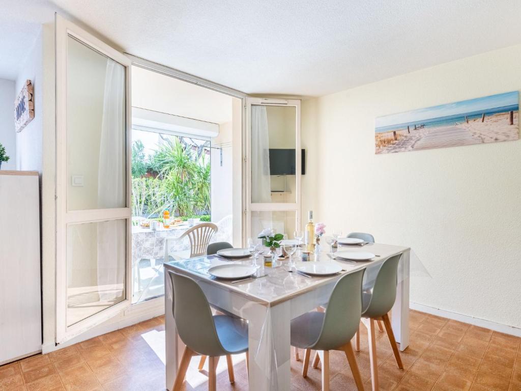 a white dining room with a table and chairs at Apartment Les Sables d'Or-8 by Interhome in Le Grau-du-Roi