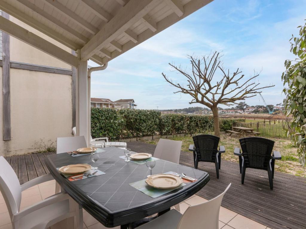 a patio with a table and chairs on a deck at Holiday Home Le Hameau des Pêcheurs 1 by Interhome in Mimizan-Plage