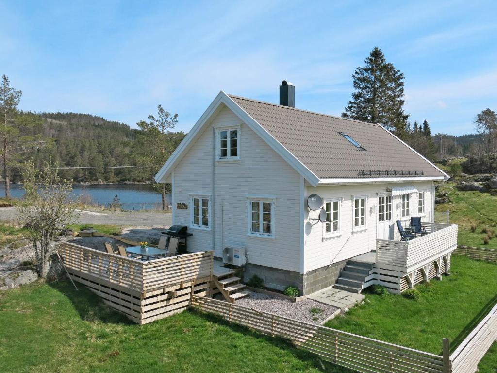 uma casa branca com um deque e um corpo de água em Holiday Home Der ute - SOW441 by Interhome em Brådland