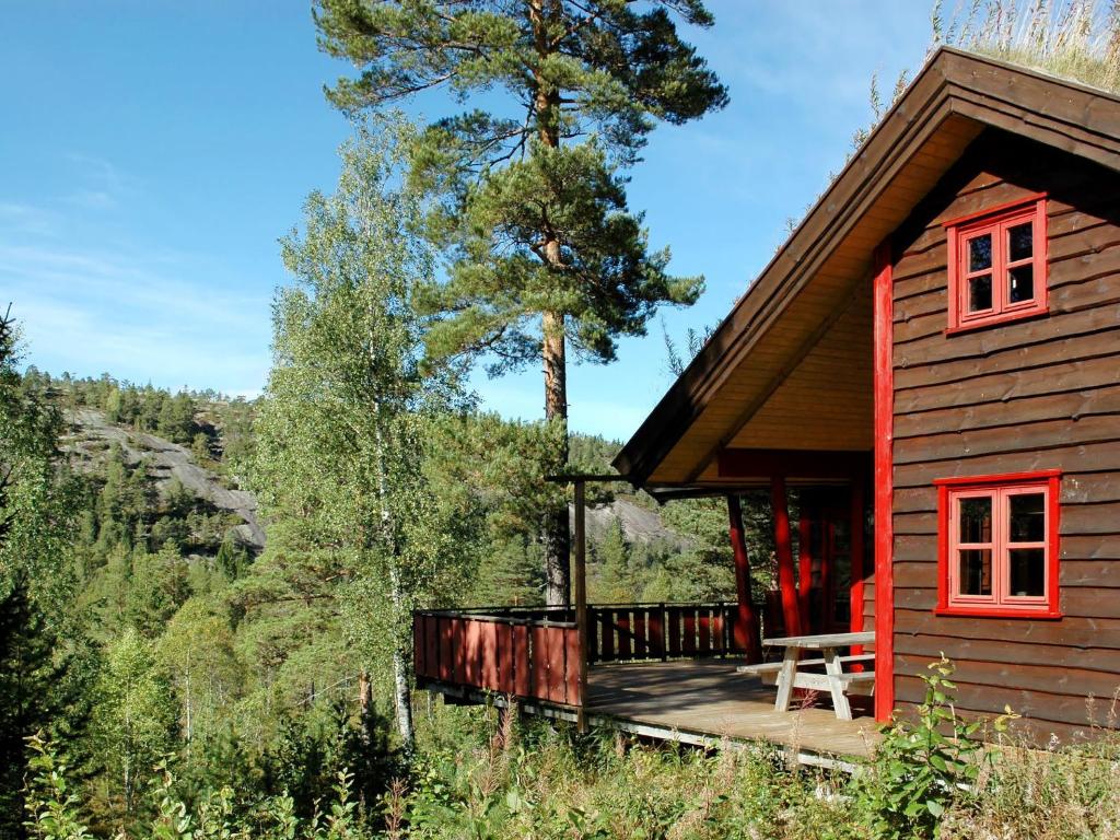 una cabina rossa con terrazza e albero di Holiday Home Troll - TEM027 by Interhome ad Åmli