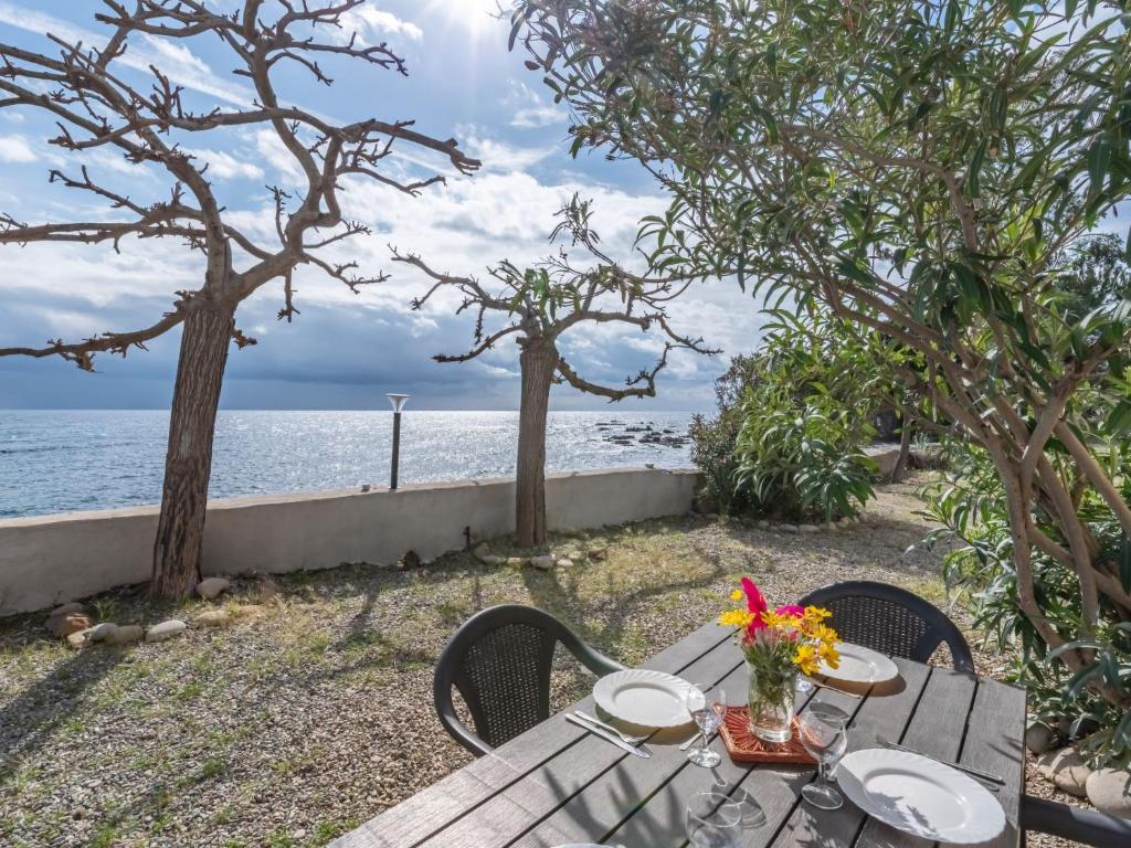 a picnic table with a view of the ocean at Holiday Home Marine di Manichinu - SOZ400 by Interhome in Sari Solenzara