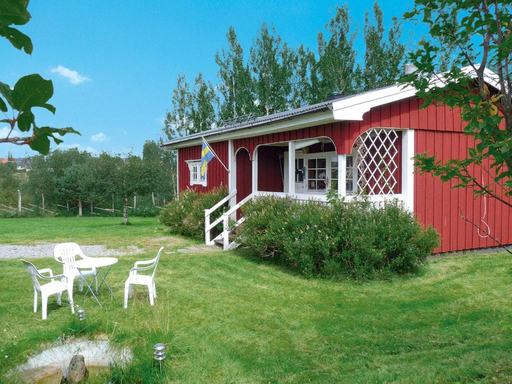 a red building with a table and chairs in a yard at Chalet Vemhån Östholmen - HJD061 by Interhome in Vemhån