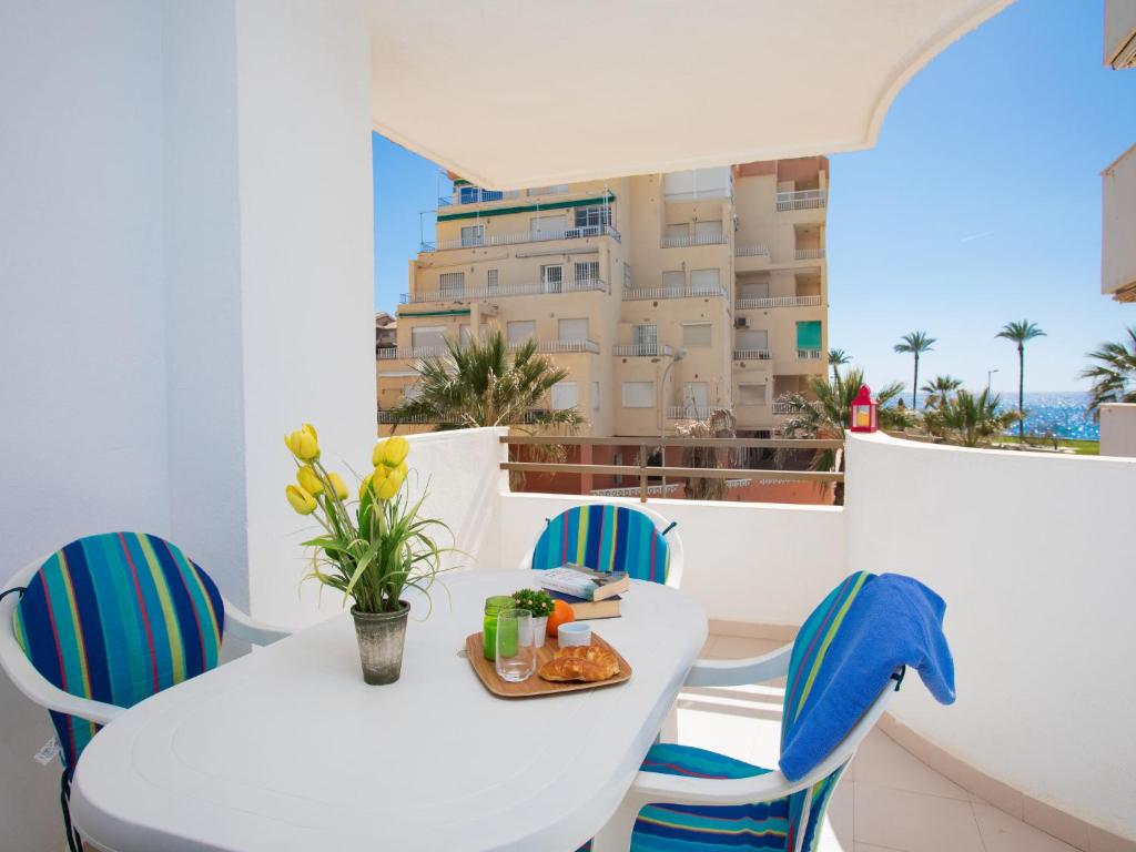 een witte tafel en stoelen met uitzicht op een gebouw bij Apartment Cala Verde II - AMU615 by Interhome in Salobreña